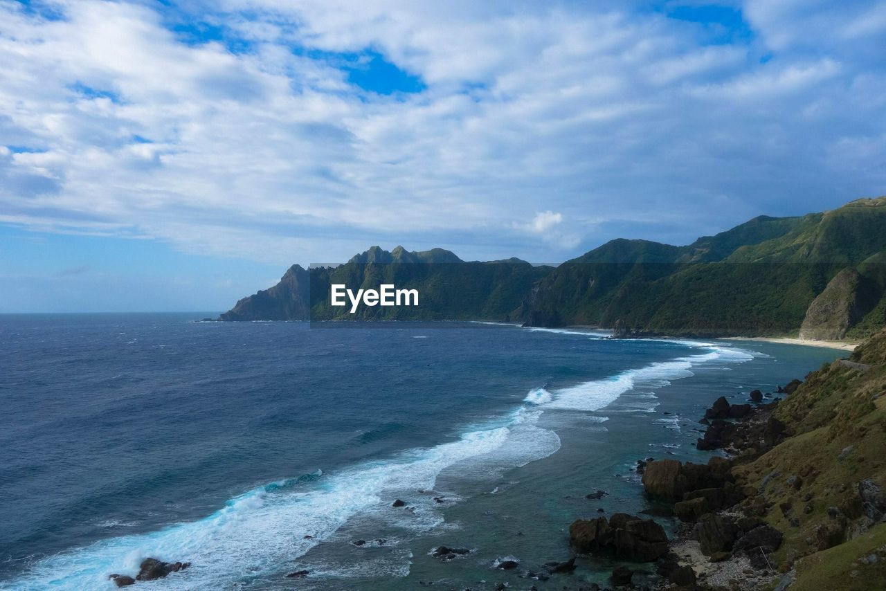 SCENIC VIEW OF SEA BY MOUNTAINS AGAINST SKY