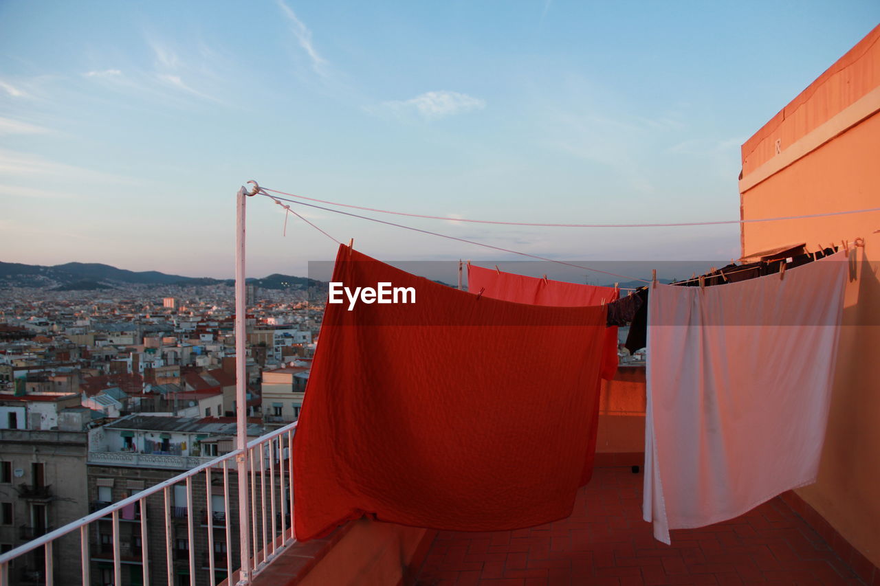 Clothes drying in building terrace against sky