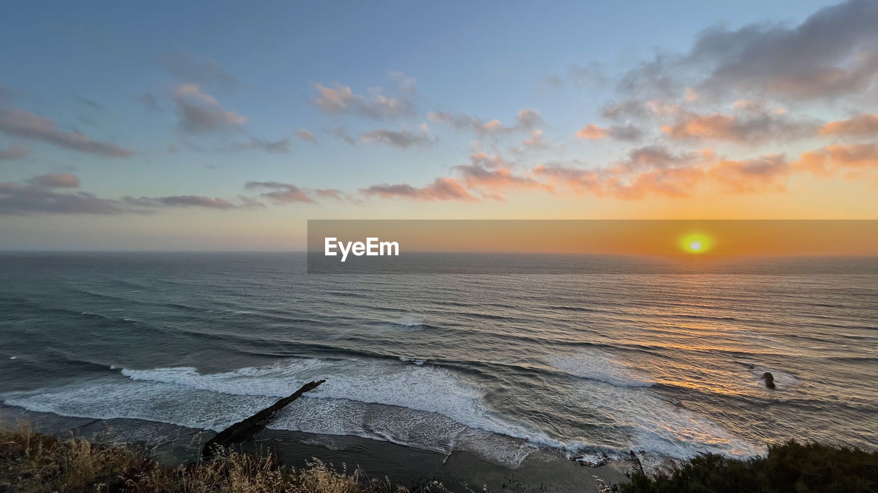 SCENIC VIEW OF SUNSET OVER SEA