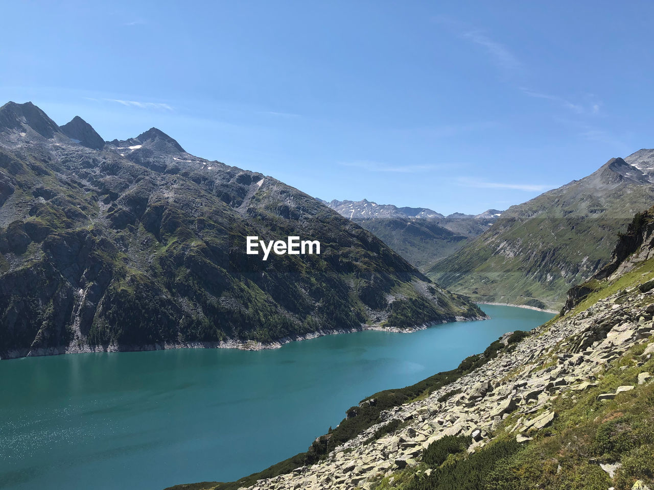 SCENIC VIEW OF LAKE BY MOUNTAINS AGAINST BLUE SKY