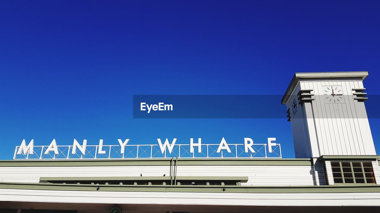 LOW ANGLE VIEW OF BUILDINGS AGAINST CLEAR BLUE SKY