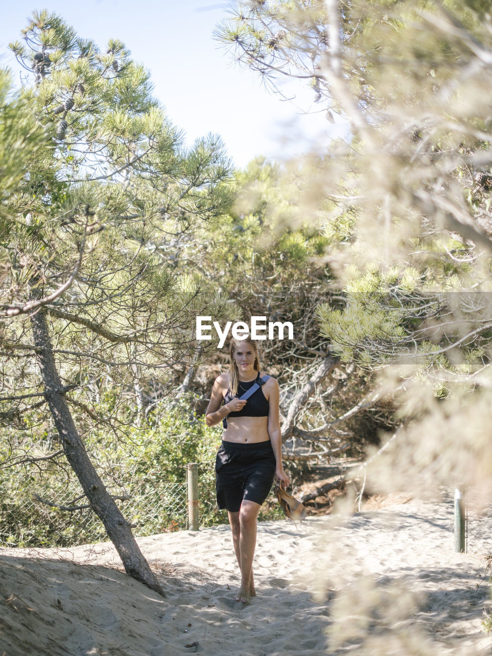 Young woman walking on beach forest
