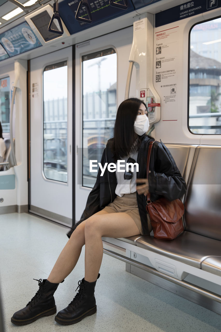 Portrait of young woman sitting in train