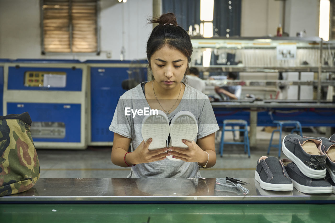 Employee doing quality control in chinese shoes factory