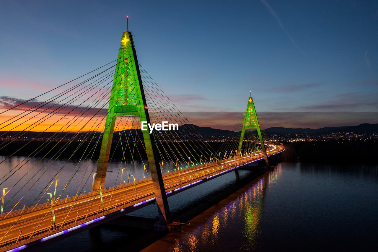 low angle view of suspension bridge against sky at night