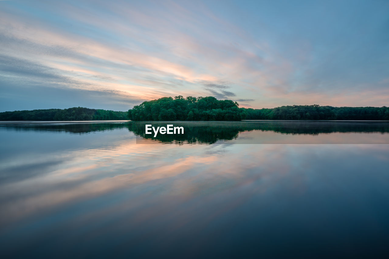 Scenic view of lake against sky at sunset