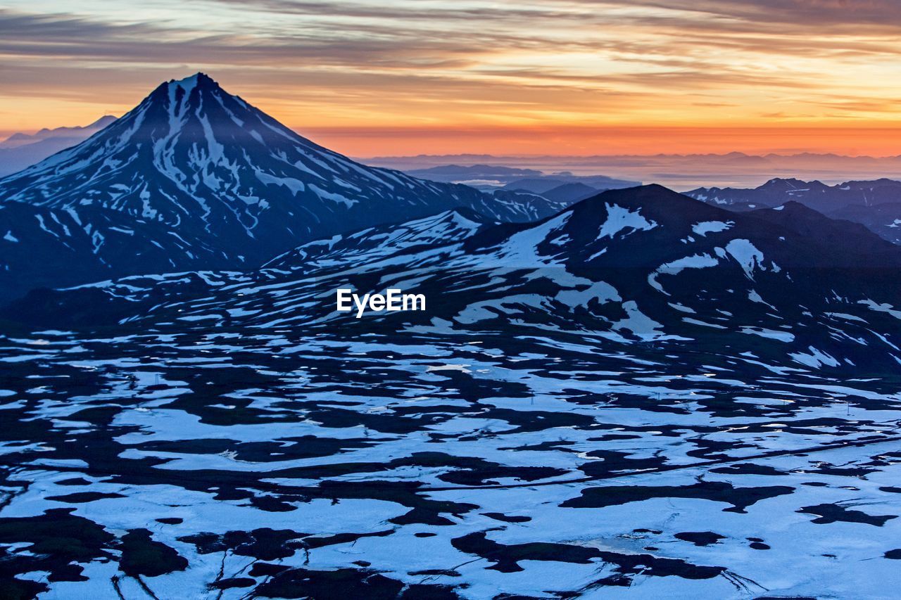 Scenic view of snow mountains against sky during sunset