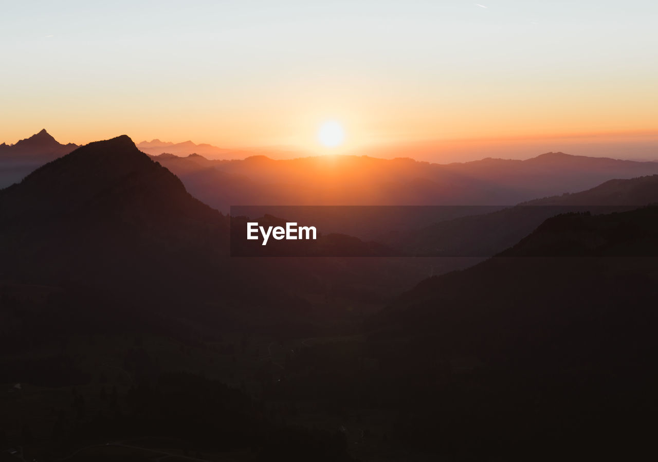 Scenic view of silhouette mountains against sky at sunset