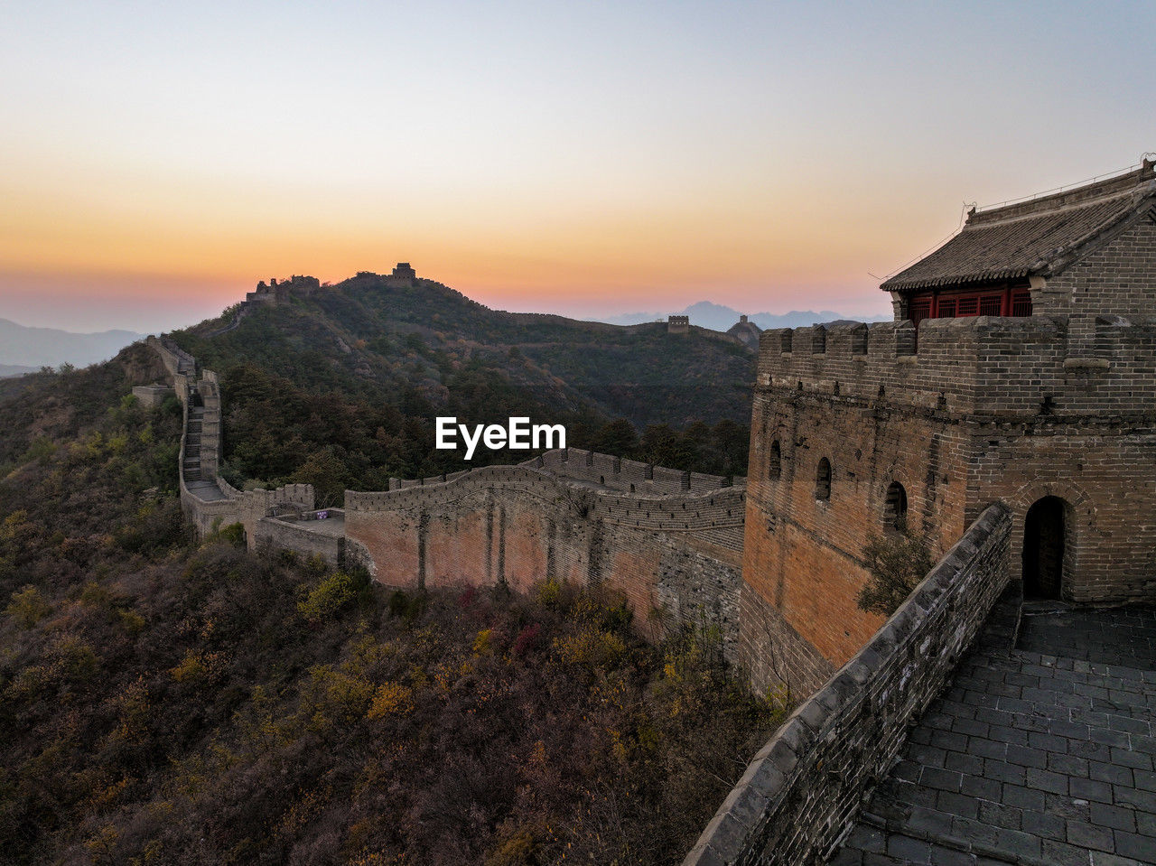 Great wall of china at sunset with rolling hills at dusk