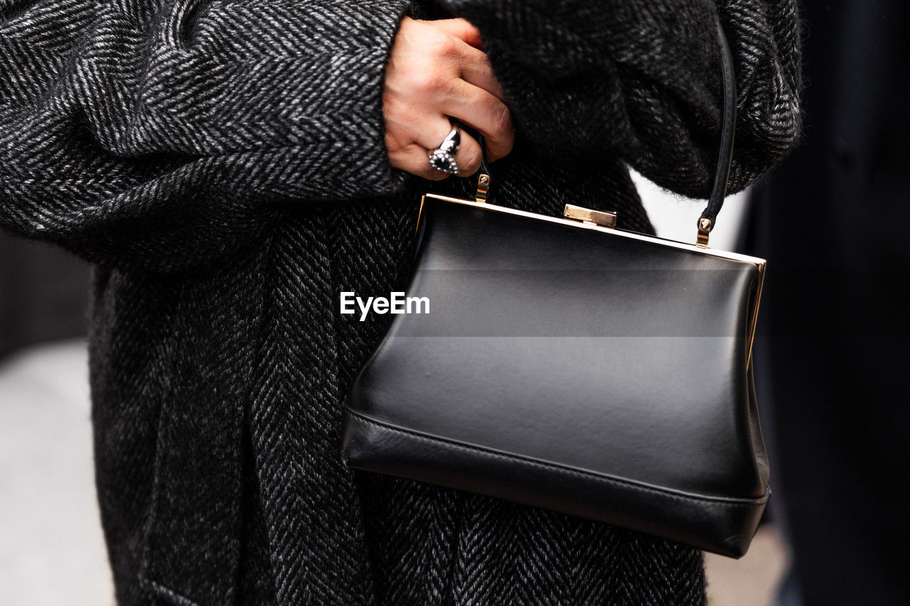 midsection of woman holding purse