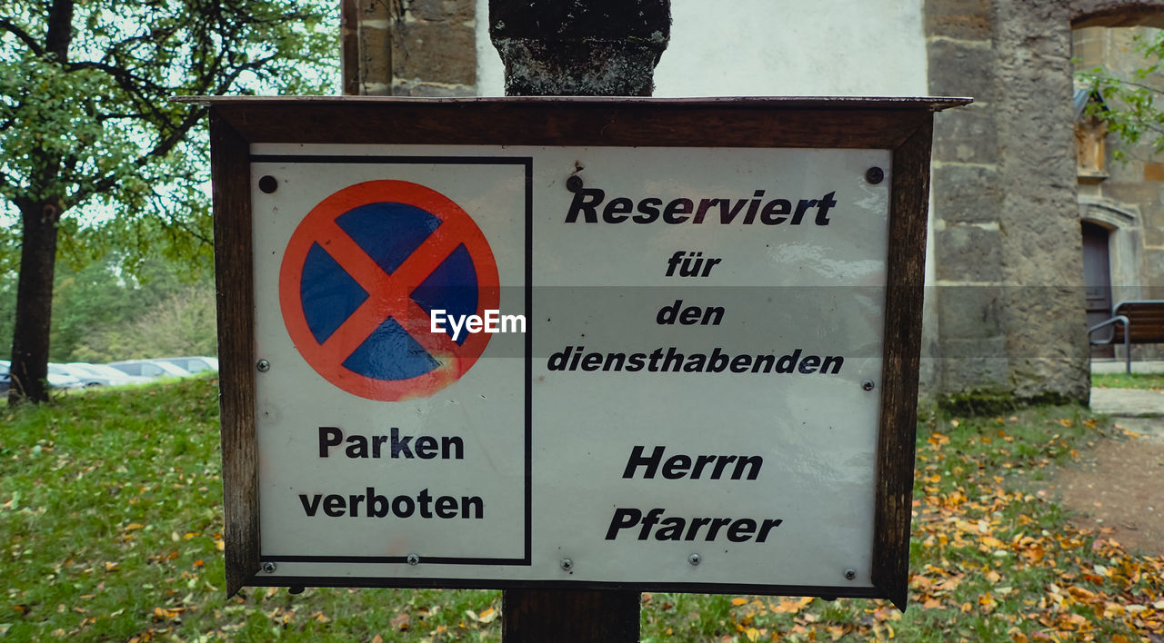 CLOSE-UP OF ROAD SIGN AGAINST PLANTS