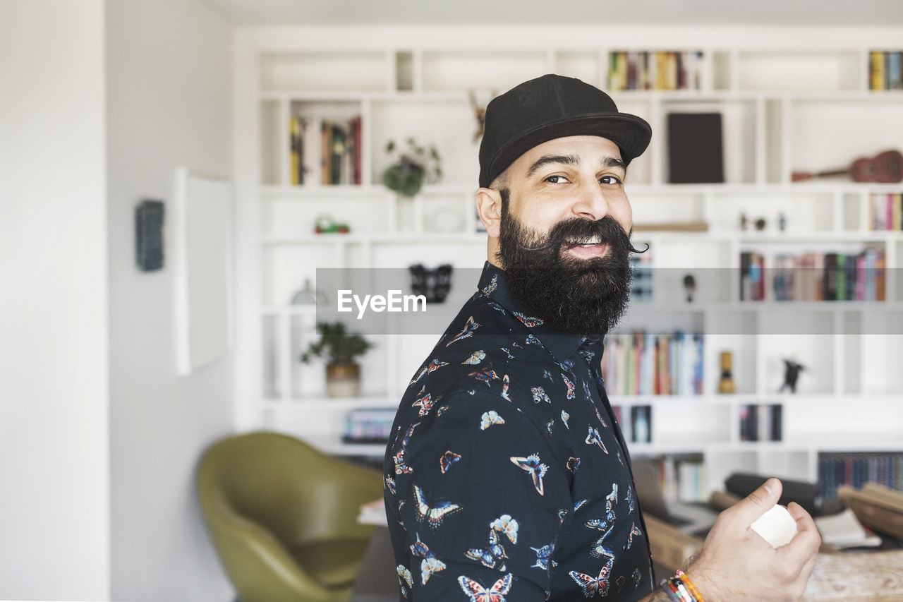 Side view of portrait of happy male architect standing in home office