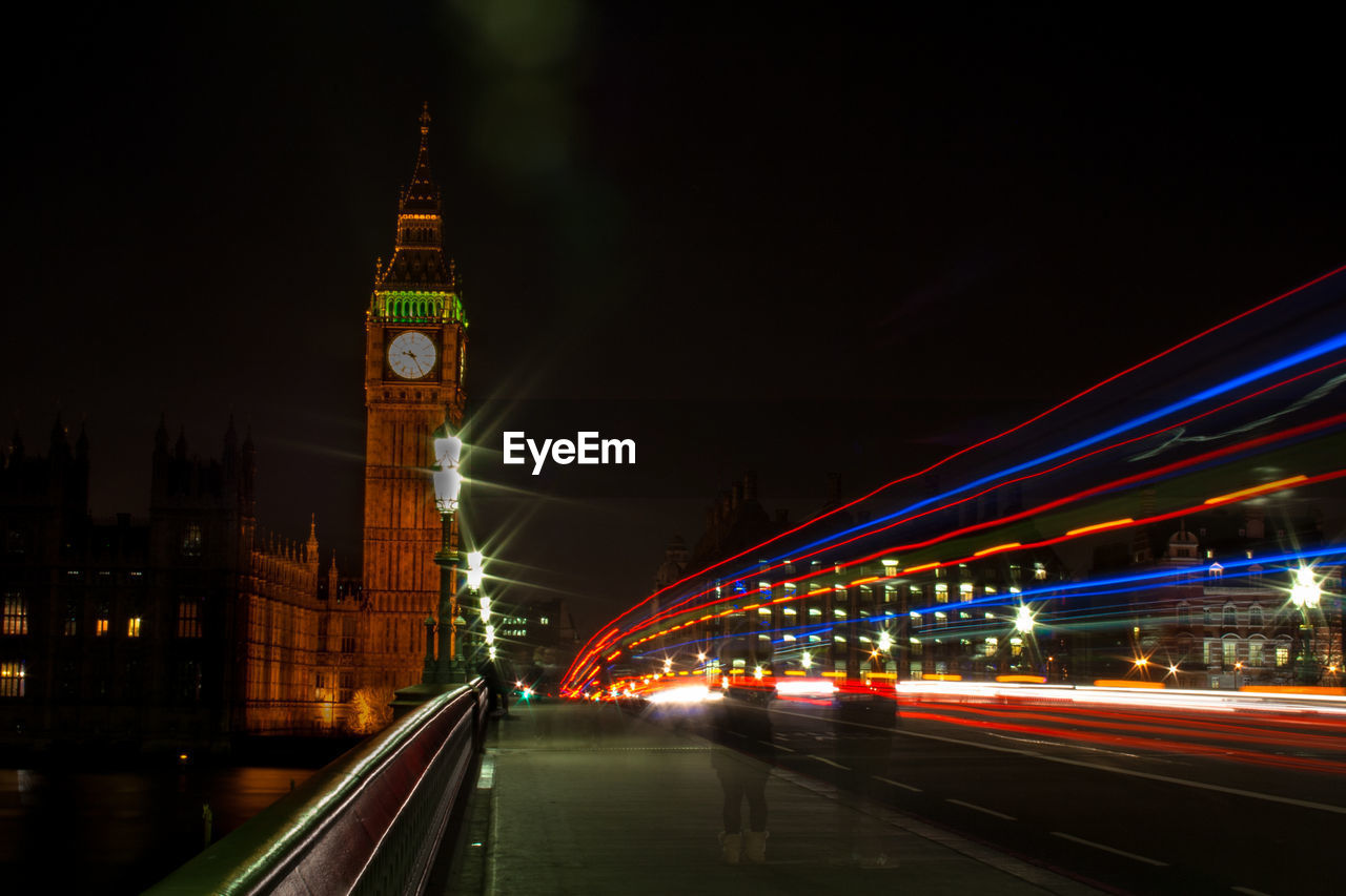 Light trails on westminster bridge by big ben in city at night