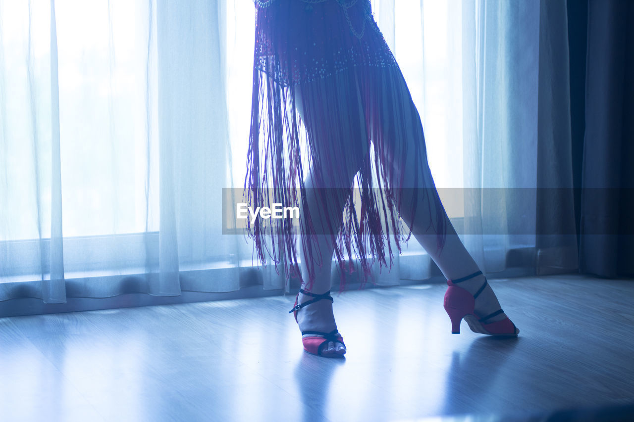 Low section of woman dancing on parquet floor at home