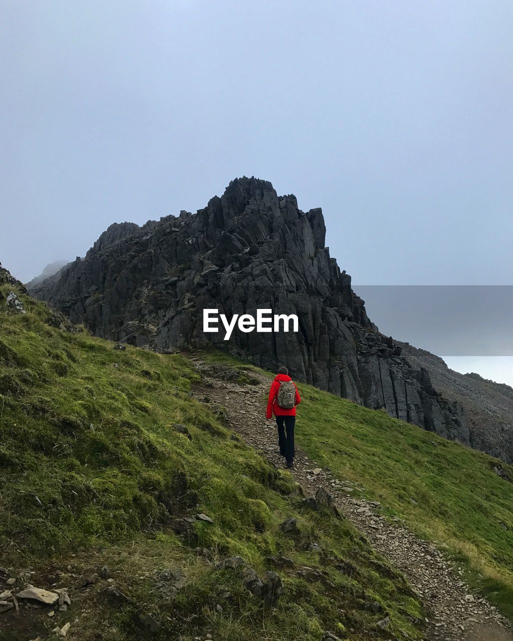 REAR VIEW OF MAN WALKING ON MOUNTAIN
