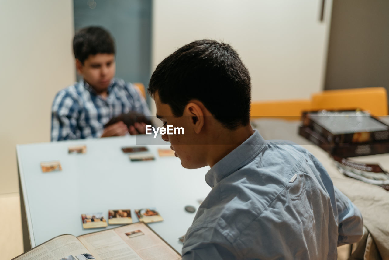 High angle view of siblings studying while sitting at table