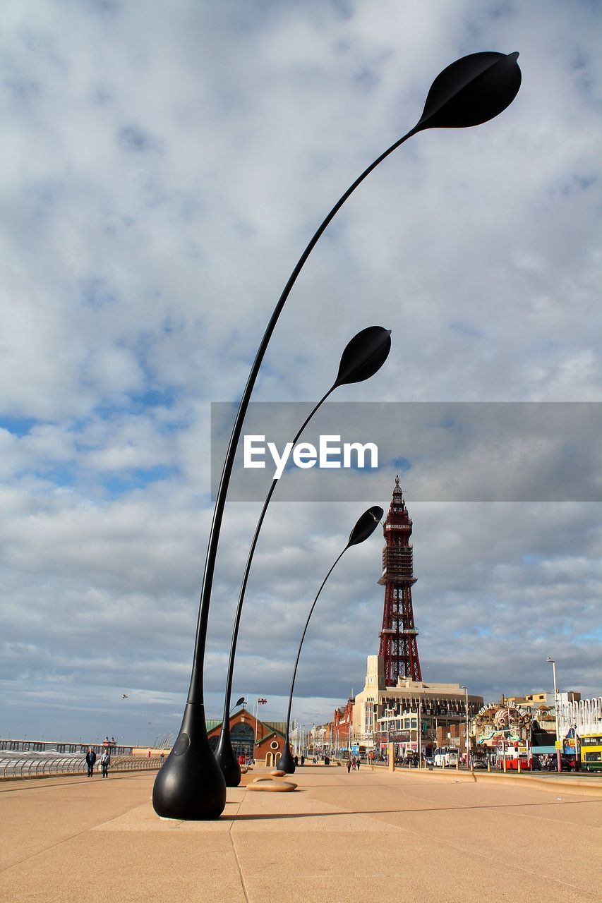 Decoration on promenade with blackpool tower against cloudy sky