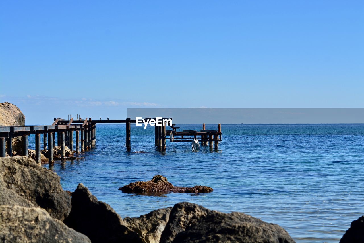 Scenic view of sea against clear blue sky