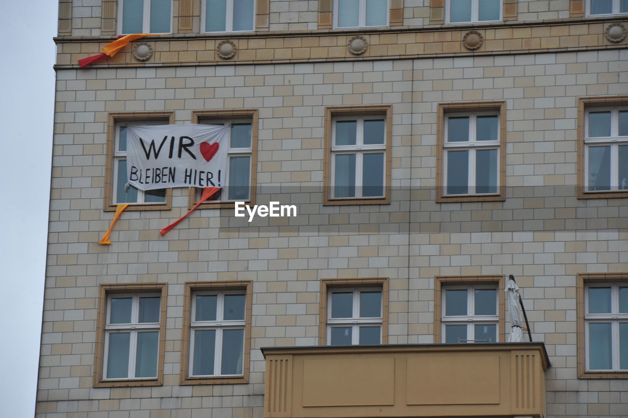 LOW ANGLE VIEW OF BUILDING WITH SIGN ON WINDOW