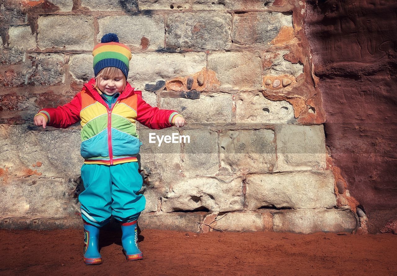 Portrait of boy standing against wall