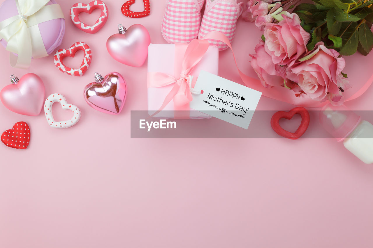 High angle view of gifts and decoration on pink table