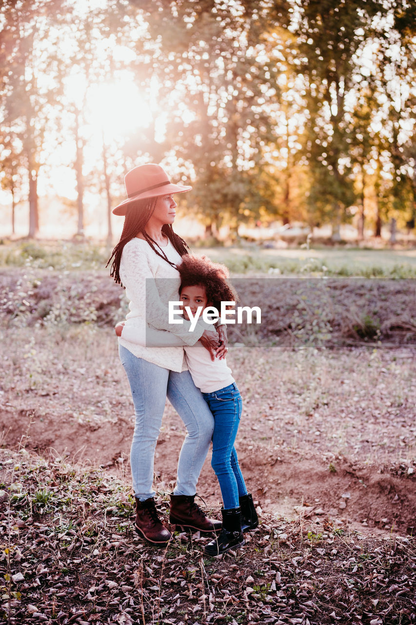 Full length of women standing on tree during autumn