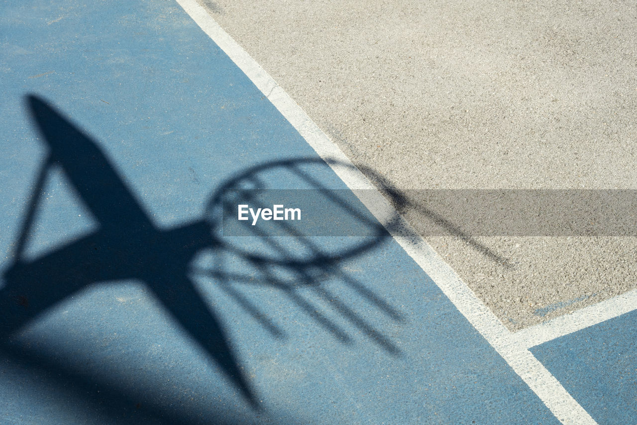 Shadow of basketball hoop on court