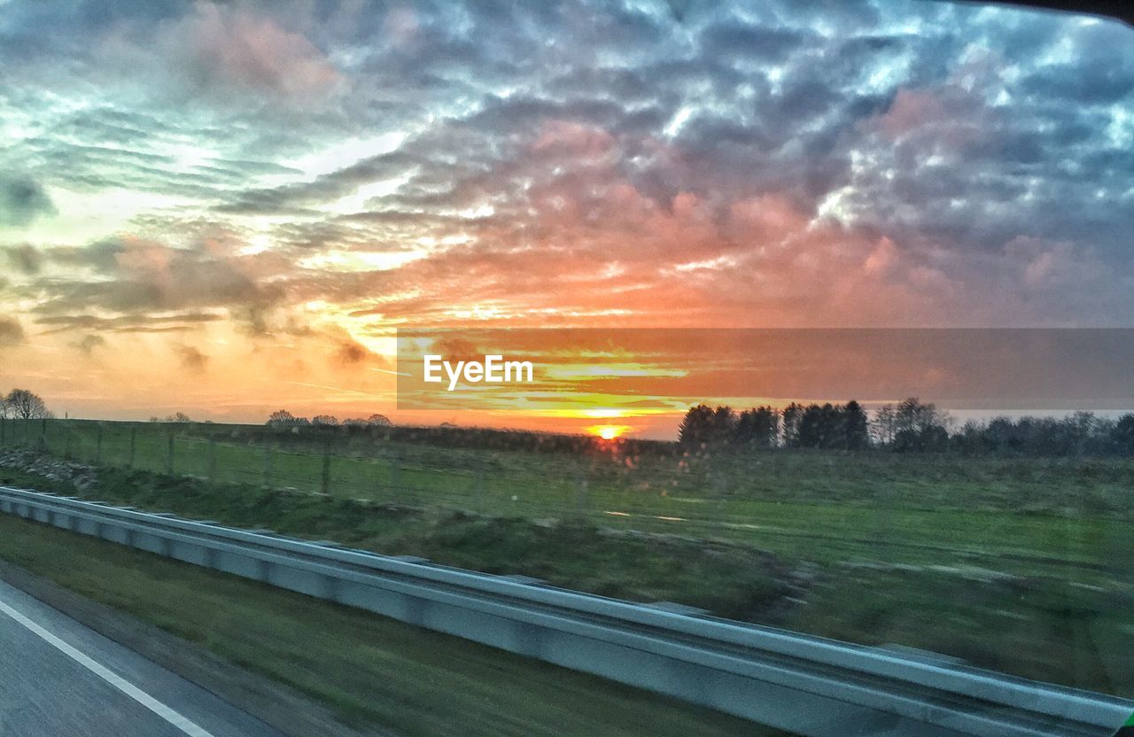 SCENIC VIEW OF LANDSCAPE AGAINST CLOUDY SKY DURING SUNSET