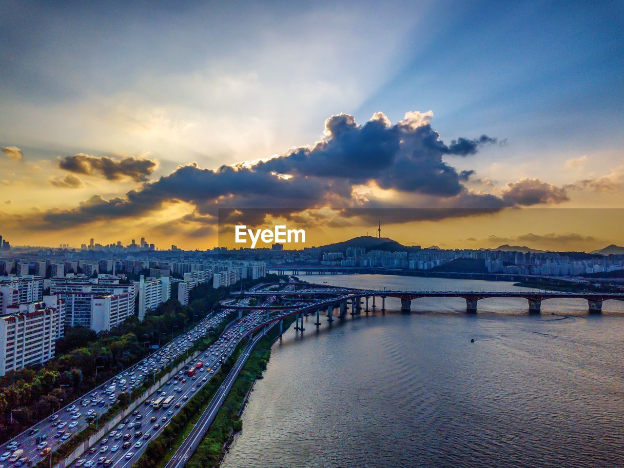 BRIDGE OVER RIVER AGAINST SKY DURING SUNSET