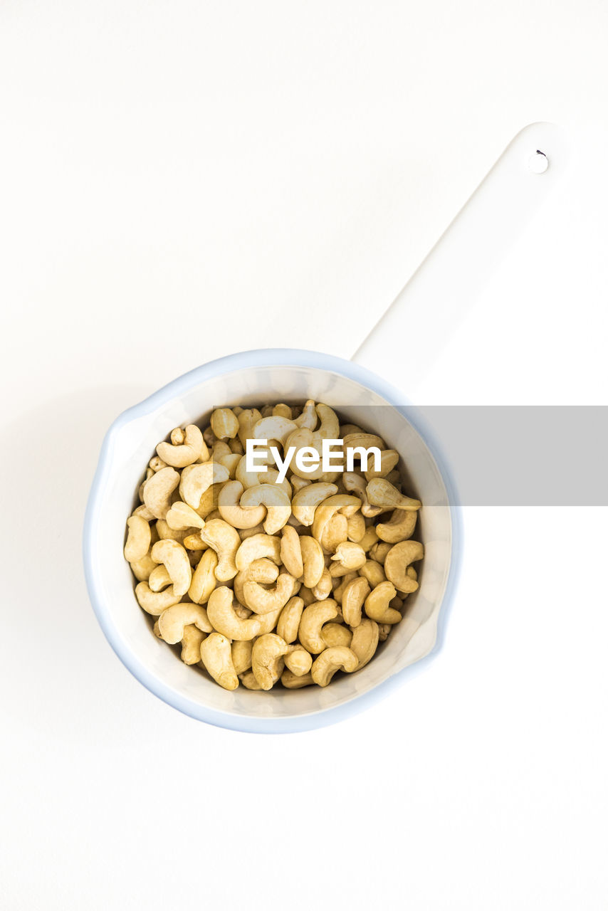 Directly above shot of cashews in bowl on white background