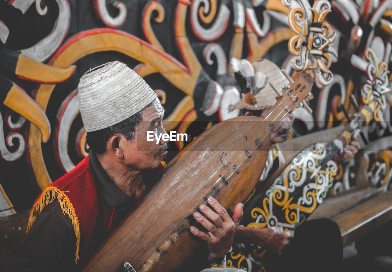 Man working on wood with musician dayaknese