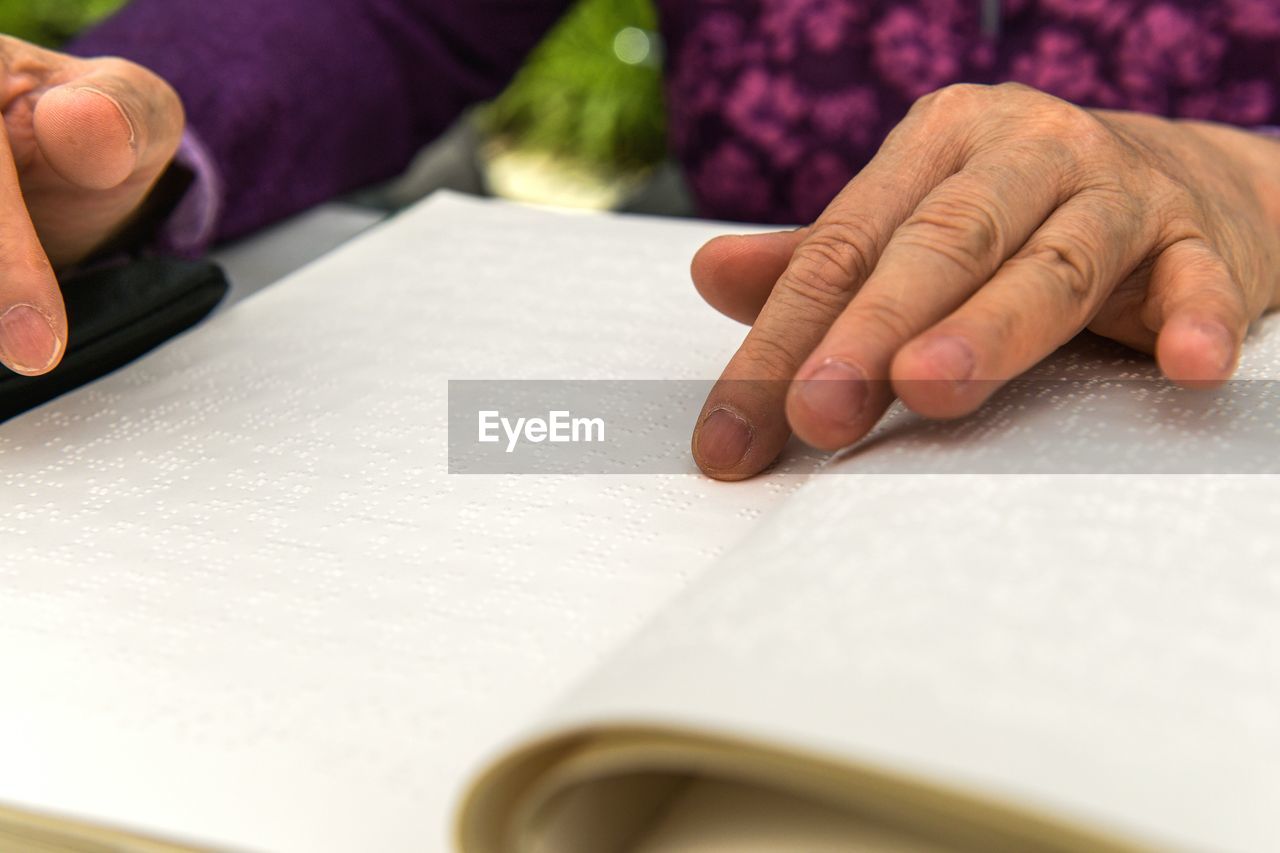 Hands of a blind person reading braille