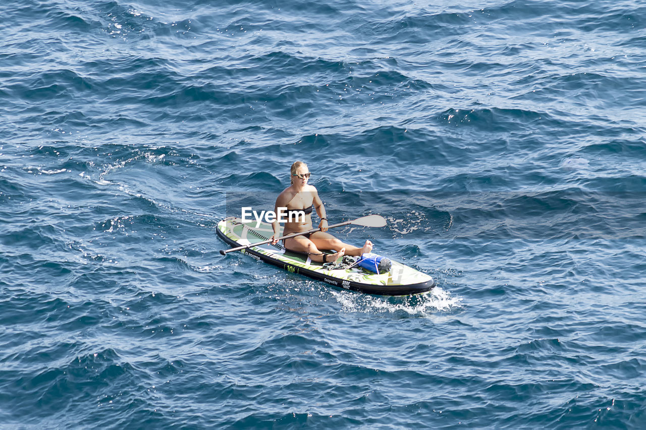 HIGH ANGLE VIEW OF PEOPLE KAYAKING IN SEA