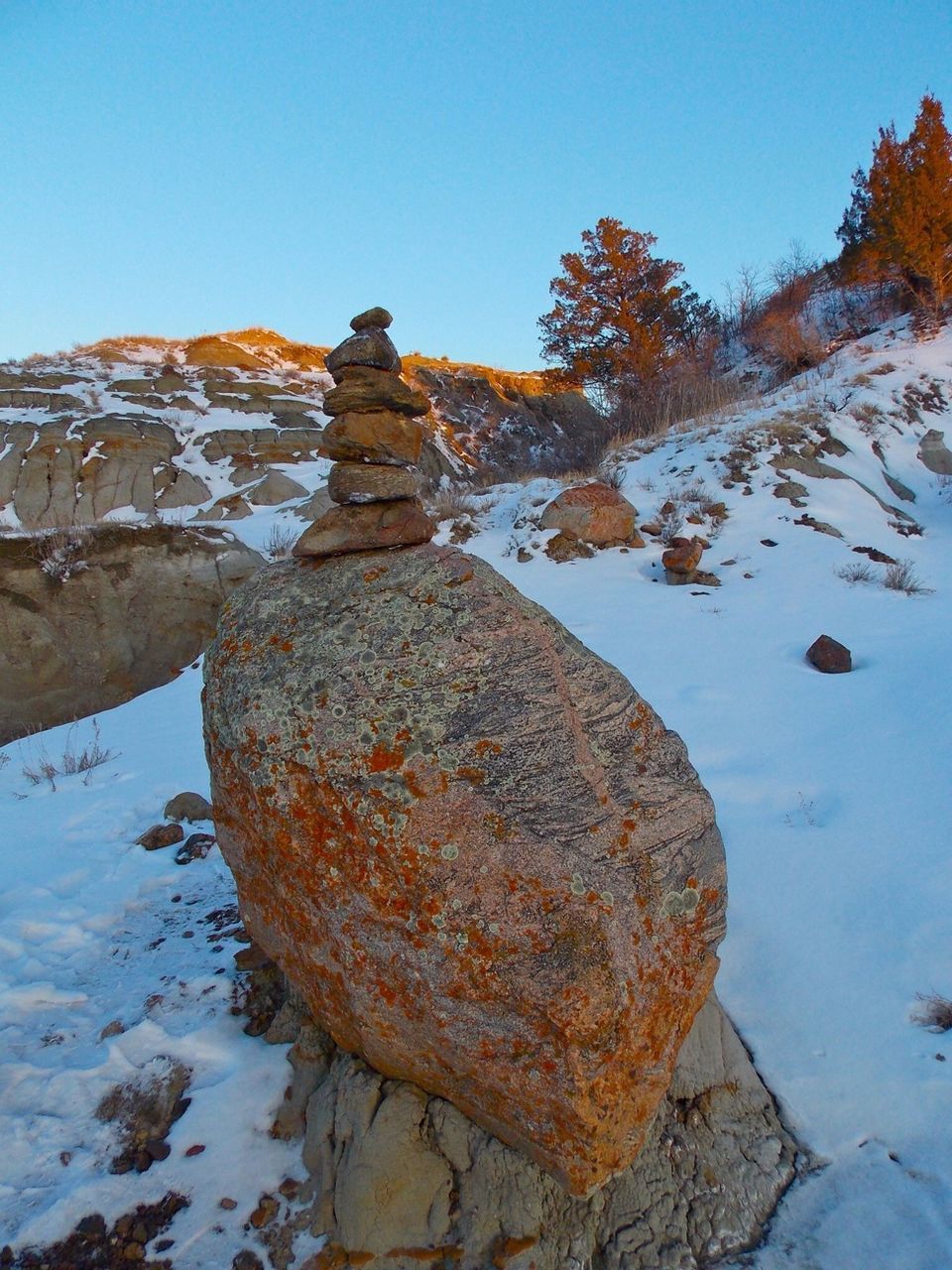 Stacked stones on rock in snow