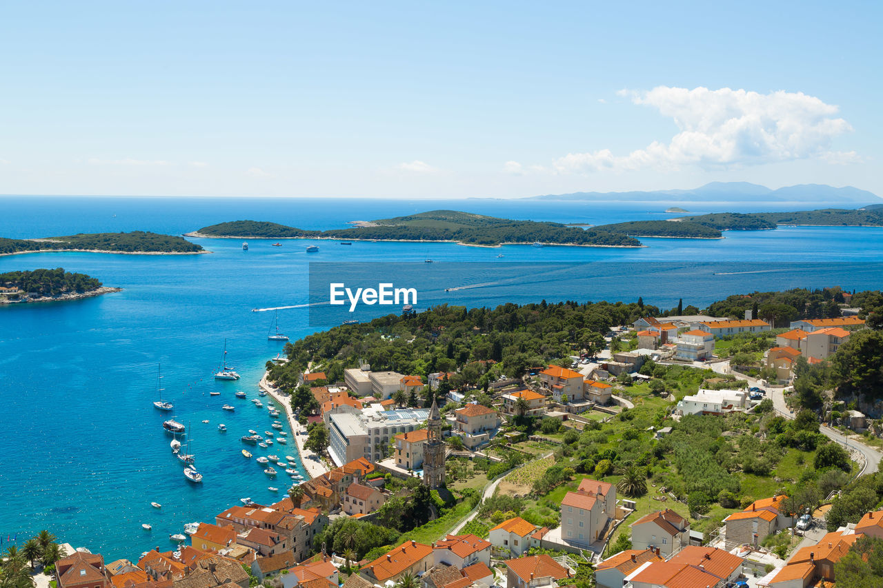 High angle view of town by sea against sky