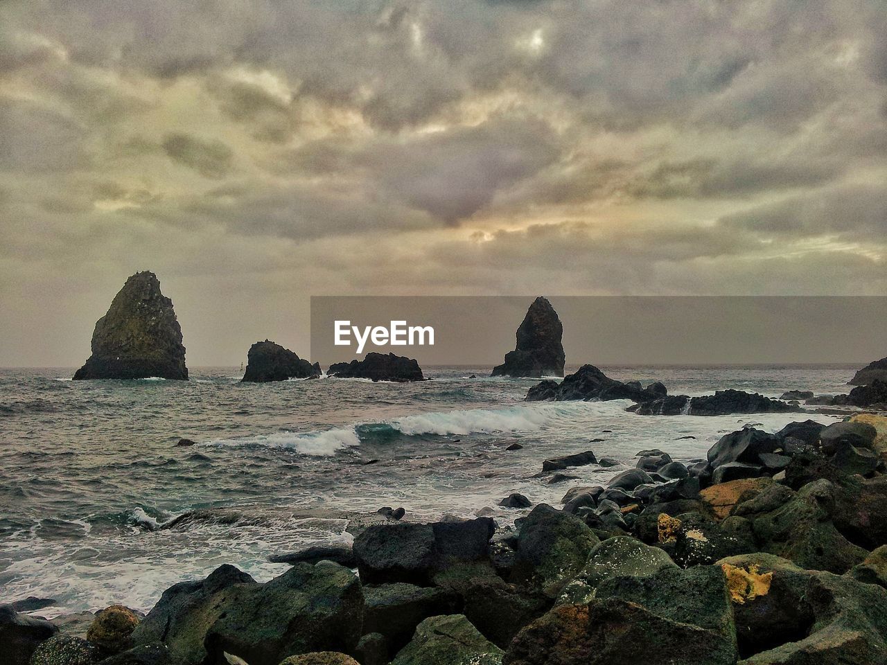 SCENIC VIEW OF ROCKS ON SHORE AGAINST SKY