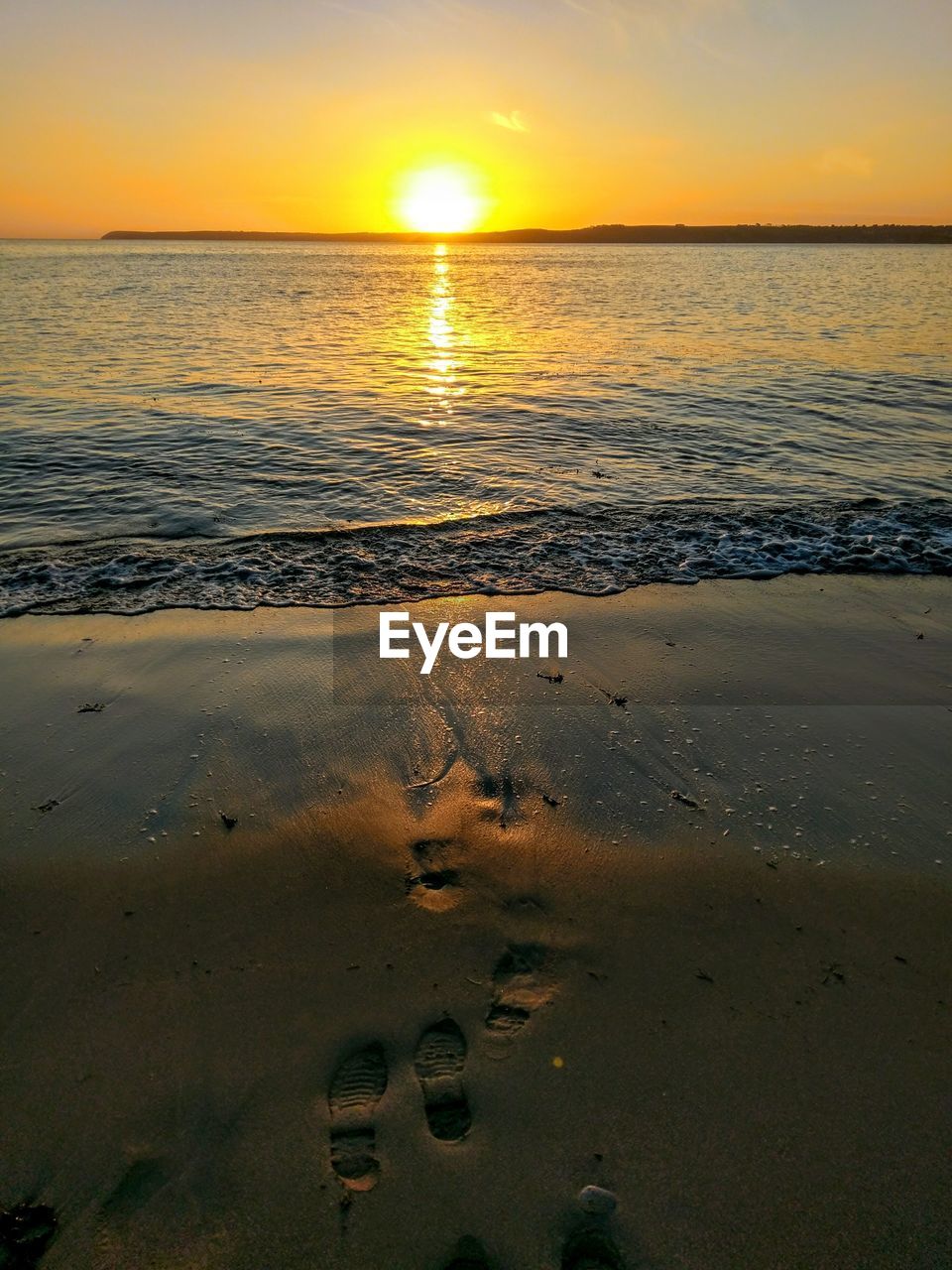 SCENIC VIEW OF BEACH AT SUNSET