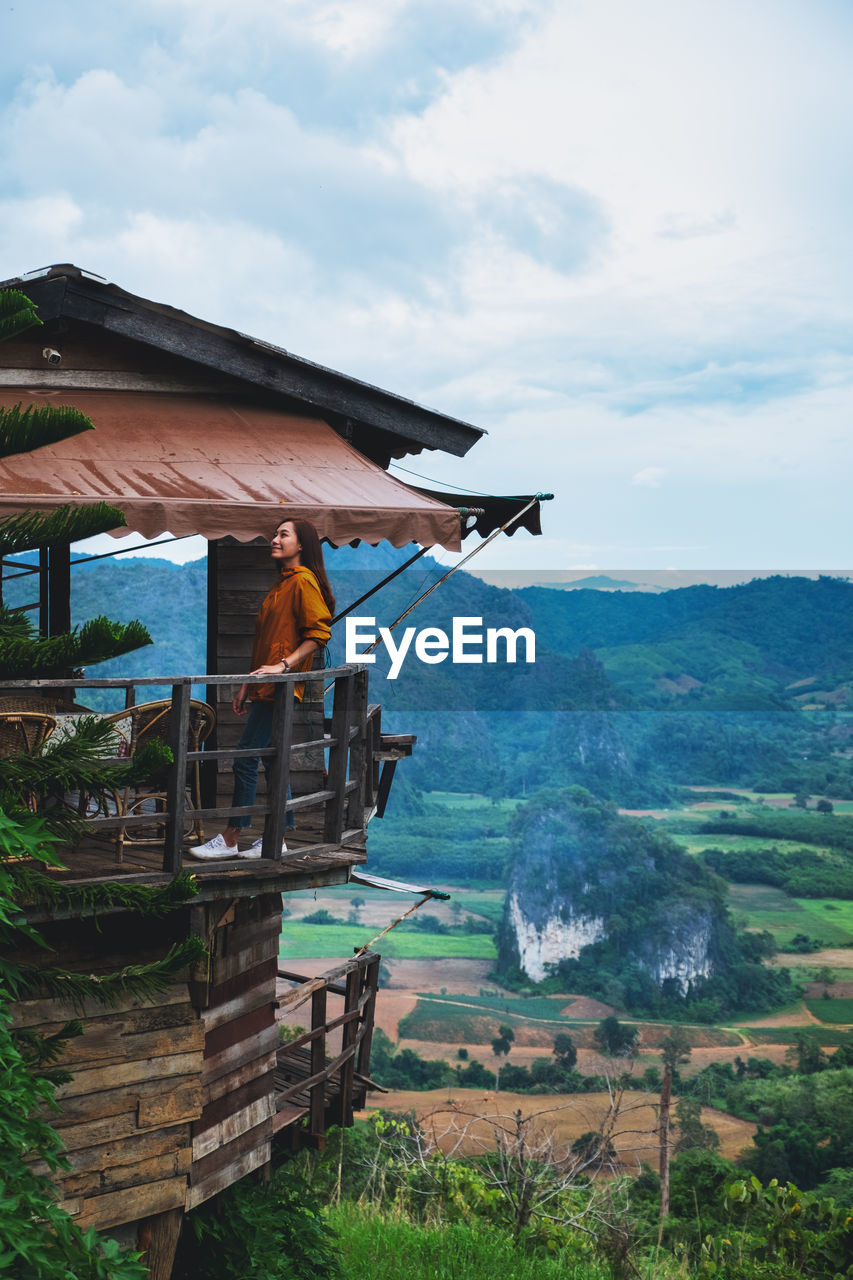 A female traveler in wooden hut with a beautiful mountain and nature view