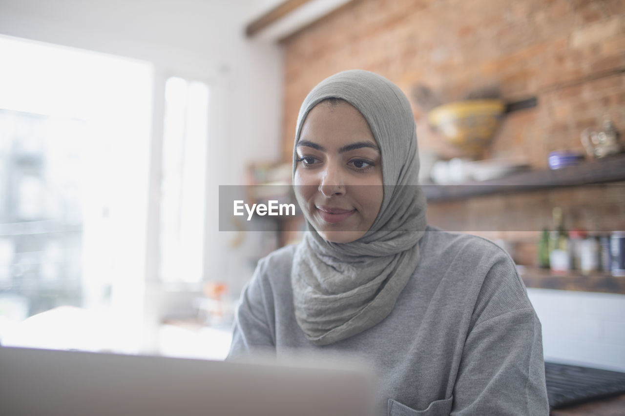 Muslim businesswoman working from home on her laptop