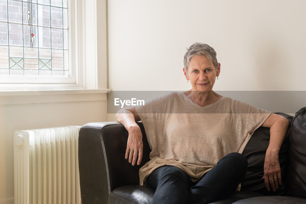 Portrait of mature woman relaxing on sofa at home