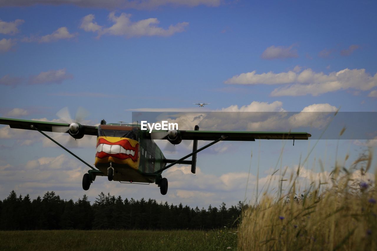 AIRPLANE FLYING ABOVE FIELD