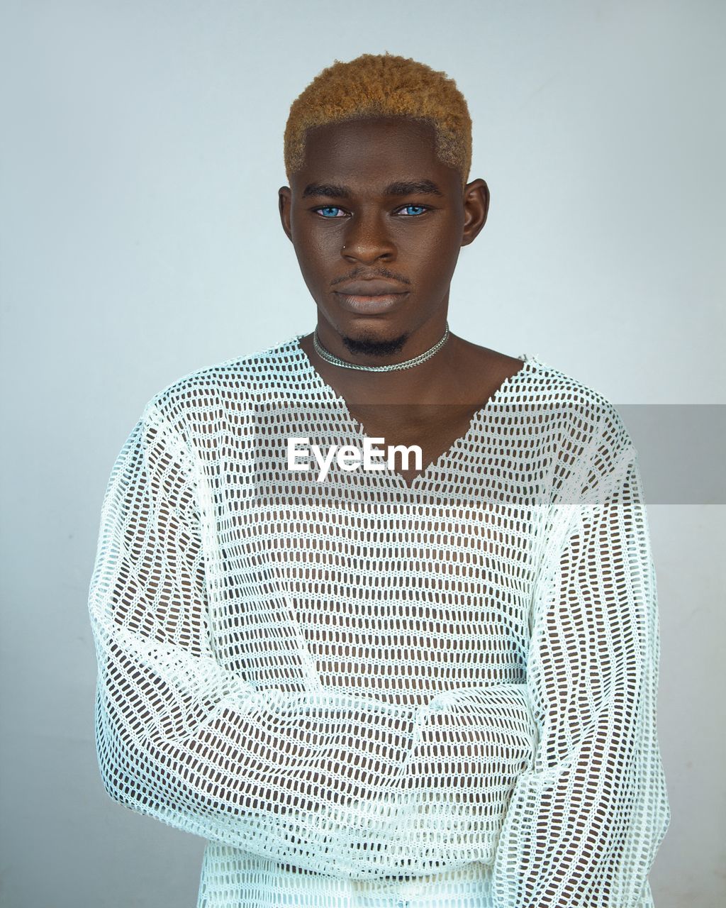 Portrait of young man standing against wall