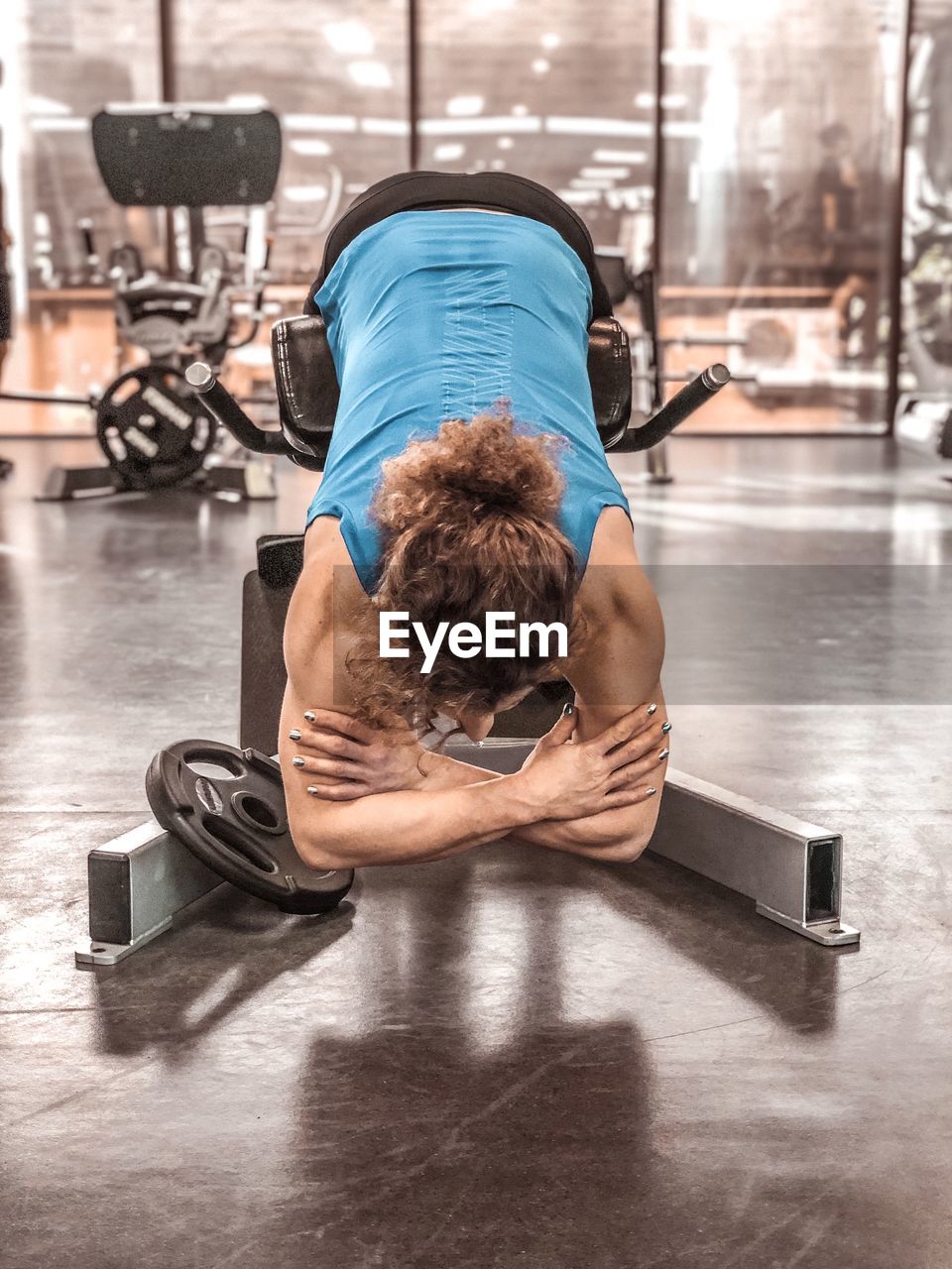 rear view of shirtless man exercising in gym