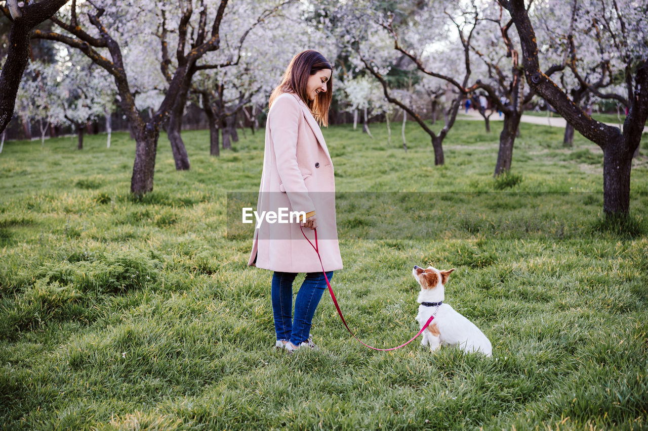 Side view of woman with dog on grass