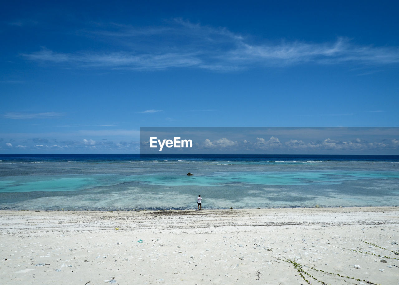 Scenic view of beach against blue sky