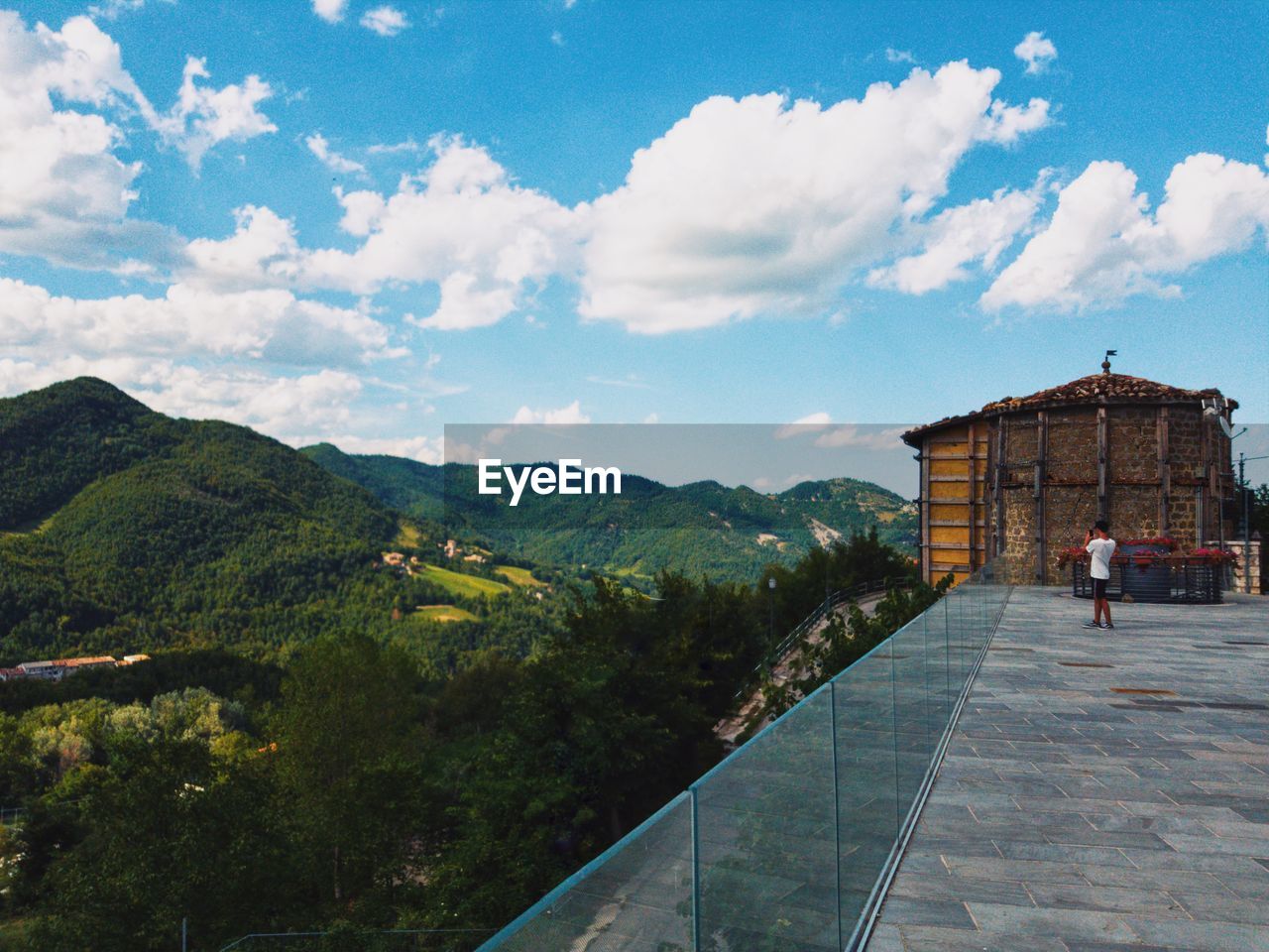 People on building by mountain against sky