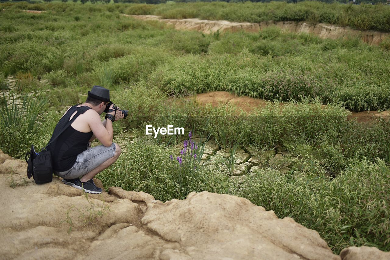 Travel photographer making photo of the nature. man in a hat.	