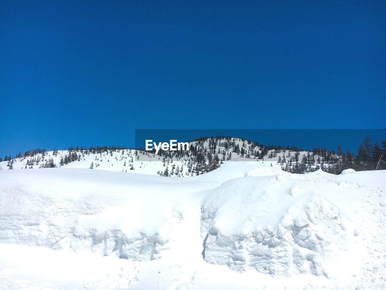 Scenic view of snowcapped mountains against clear blue sky