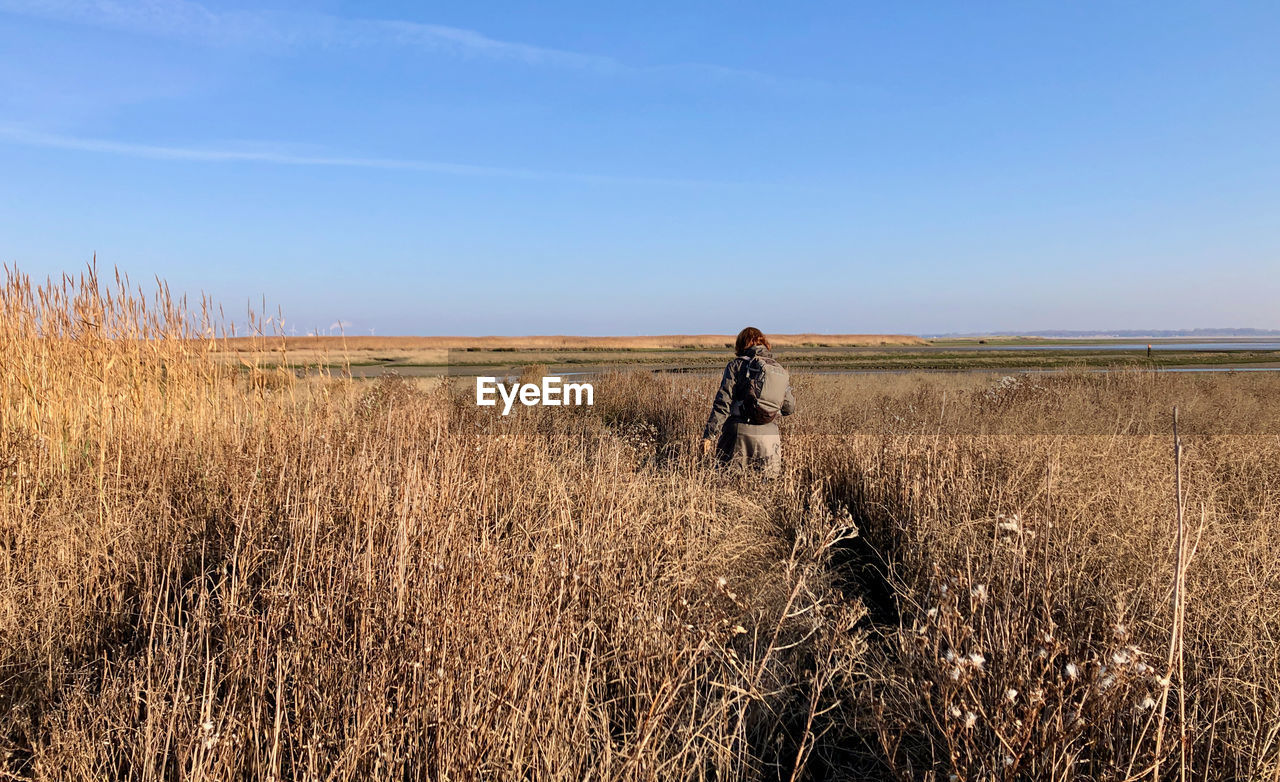 Woman standing on land against sky