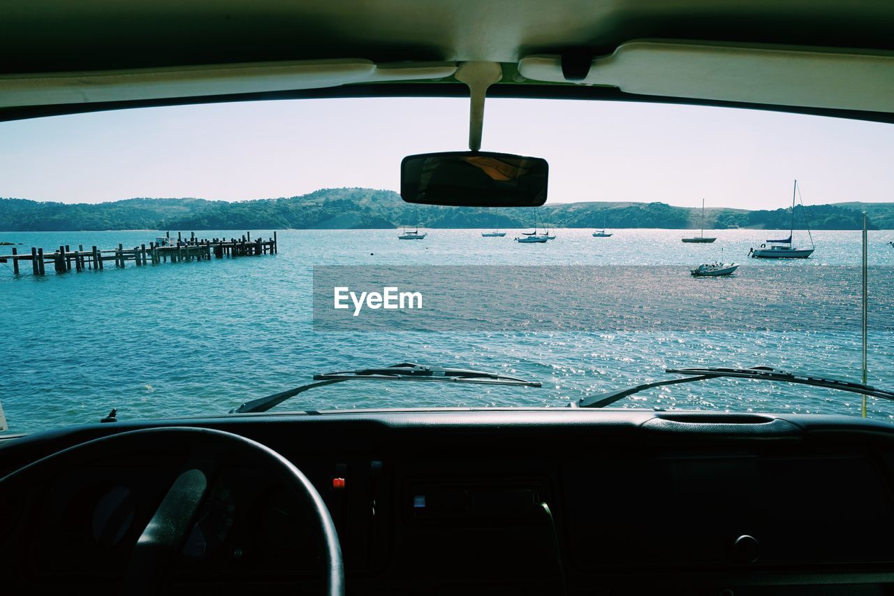 Sea seen through windshield against sky